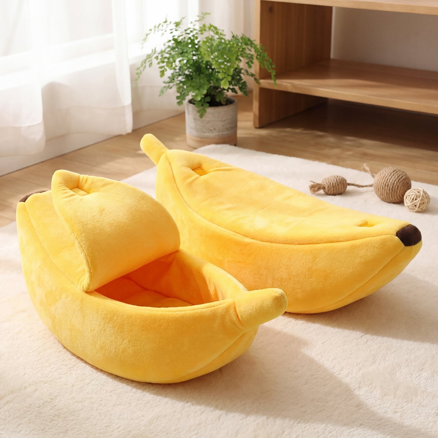 Two yellow banana-shaped pet beds on a light-colored rug with a plant and wooden shelf in the background.